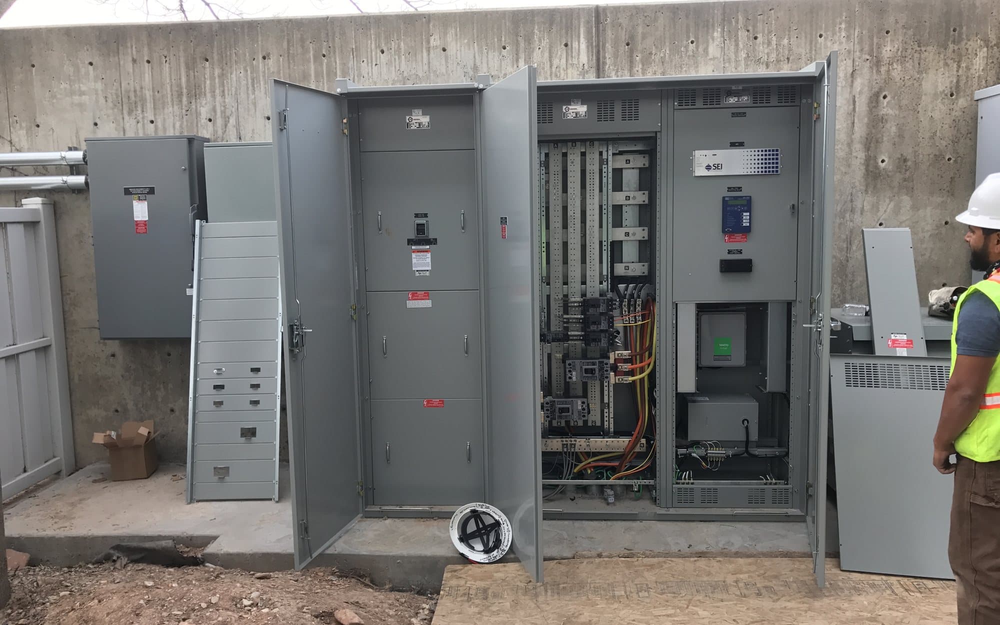 Electrician working on a commercial breaker panel with neatly run wiring